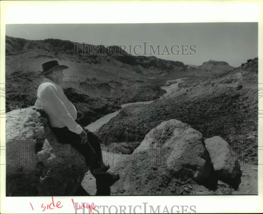 1993 Press Photo Man leans on boulder in &quot;Hands Across the Border&quot; series - Historic Images