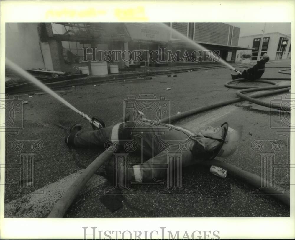 1989 Press Photo Houston Firefighter Ricky Faulk lies on his back to fight fire - Historic Images