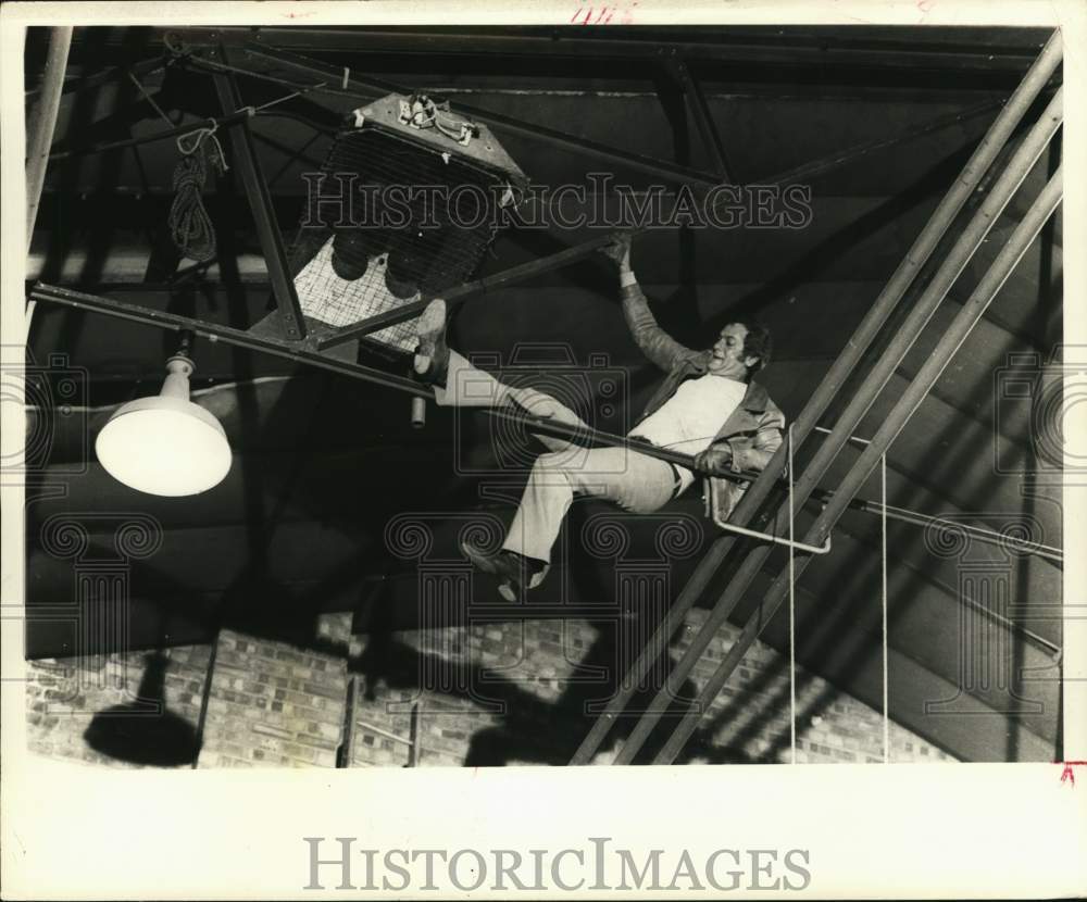 1971 Press Photo Actor Tony Curtis climbs around ceiling pipes in a plant - Historic Images