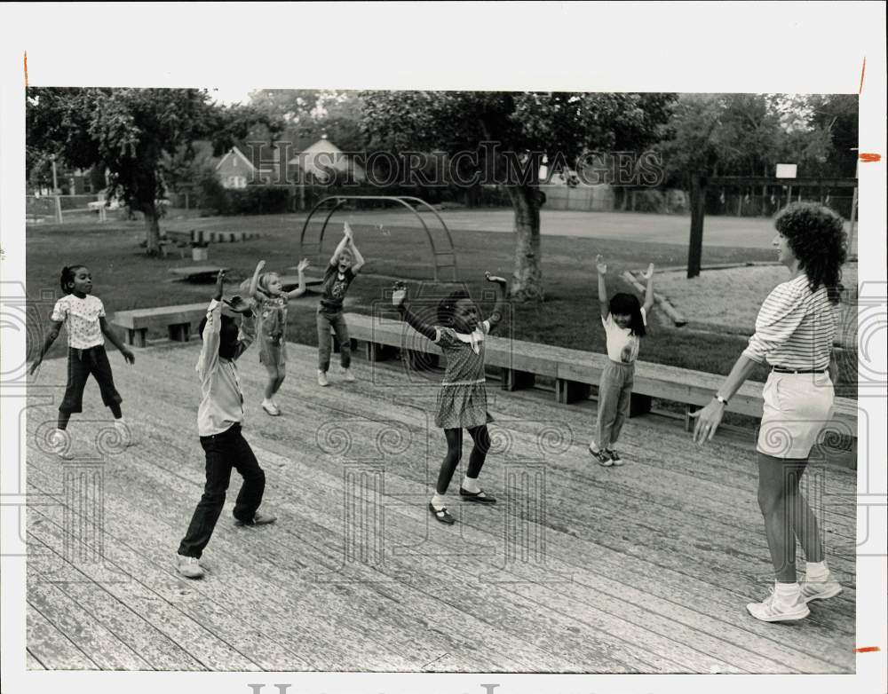 1985 Press Photo Pat Sutton and students of Roberts Elementary perform exercises - Historic Images