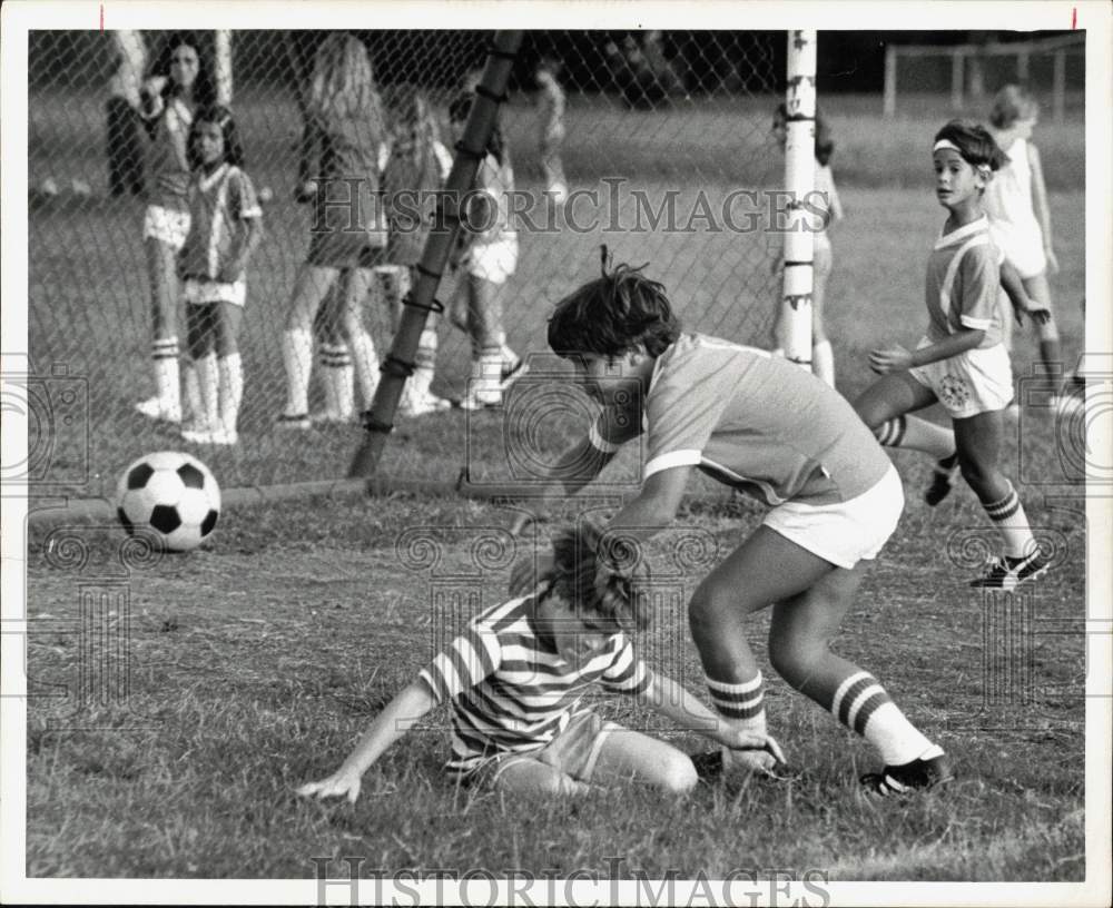 1975 Press Photo One player hits the ground during soccer game action.- Historic Images