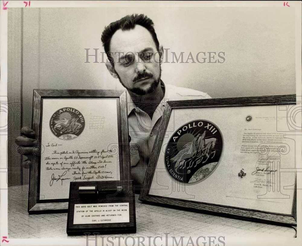 1972 Press Photo Earl Guthridge, Aerospace worker, shows space items. - Historic Images