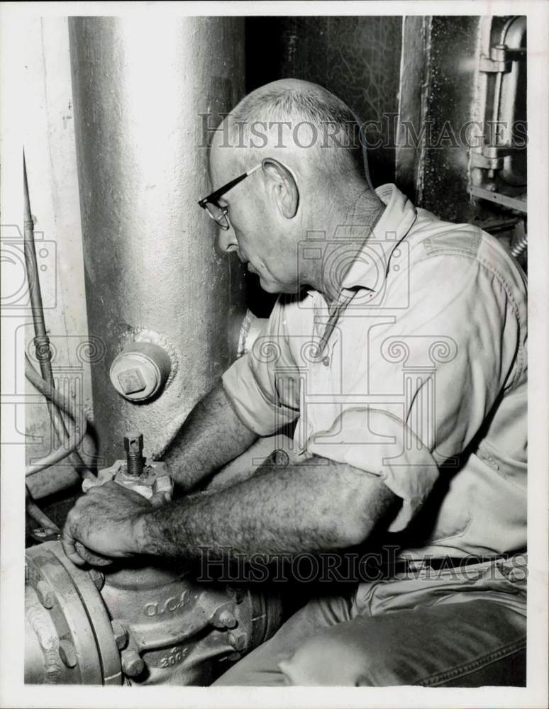 1963 Press Photo Custodian N.C. Blackwell works on boiler - hpa62816- Historic Images