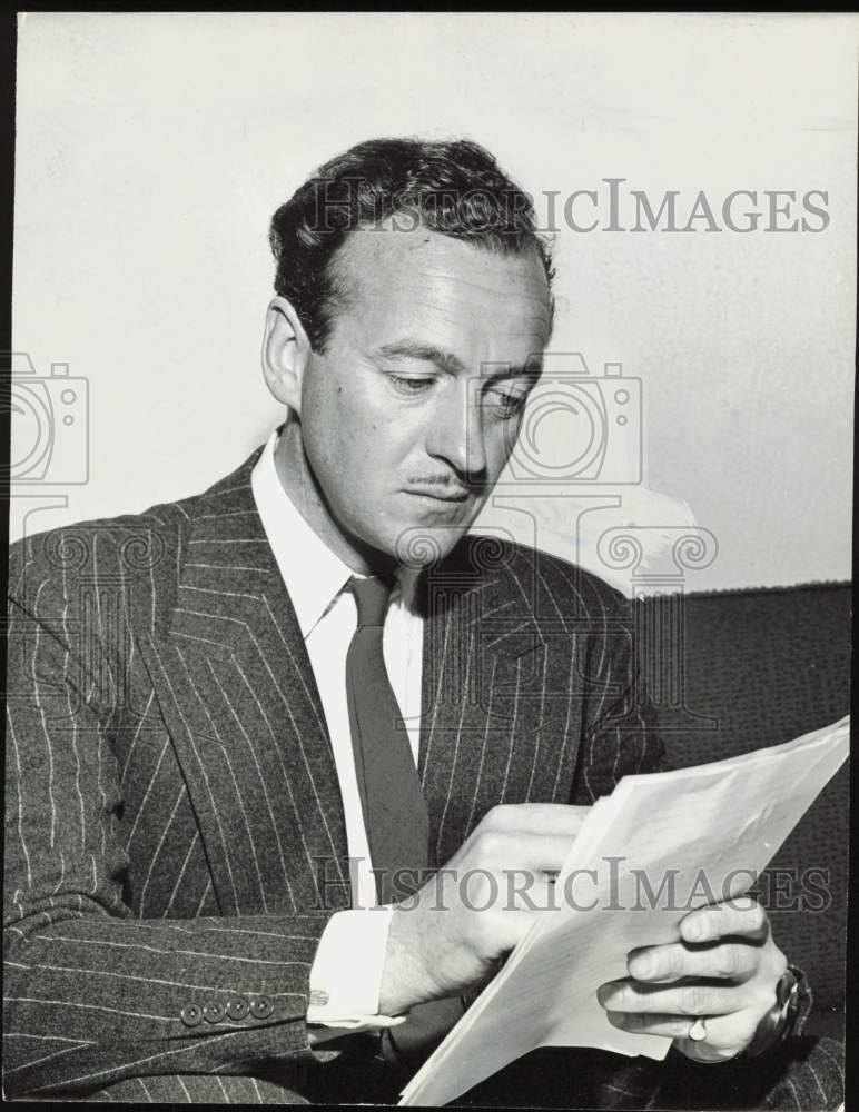 1956 Press Photo David Niven, actor, looks over papers. - hpa85337- Historic Images