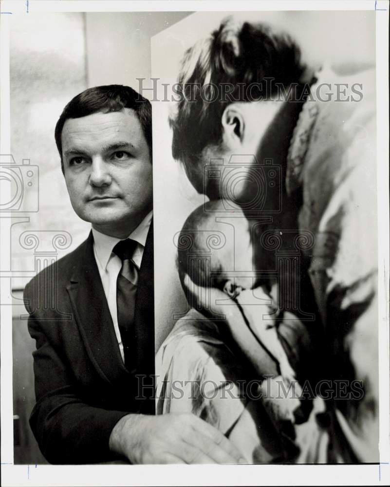 1969 Press Photo Norman Fleishman of Planned Parenthood posed with poster.- Historic Images