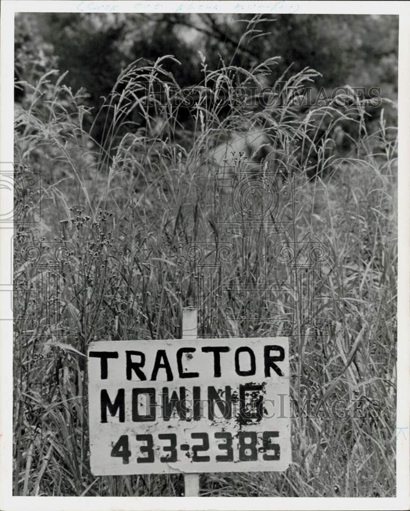 1974 Press Photo Tractor Mowing sign placed near overgrown lot. - hpa91757- Historic Images