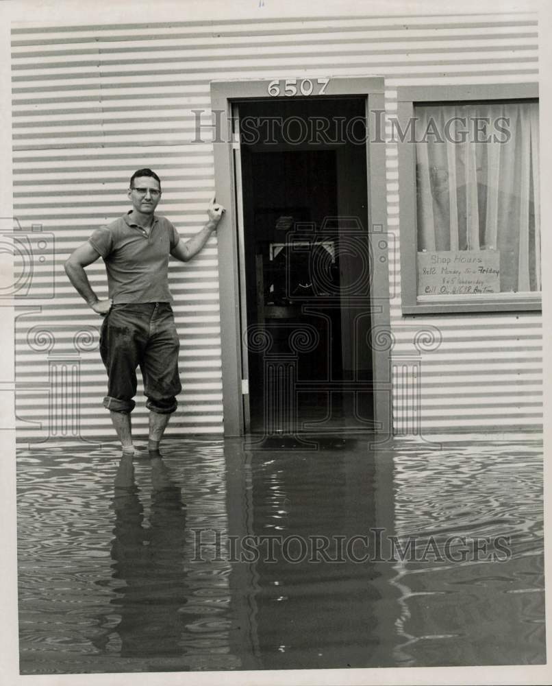 1959 Press Photo Allen Robinson stands outside his flooded Glass &amp; Mirror shop.- Historic Images