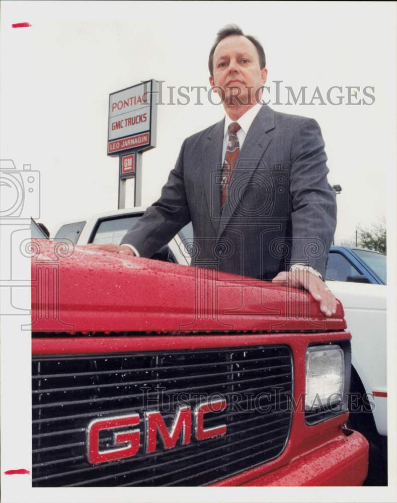 1991 Press Photo Sid Jarnigan of Leo Jarnigan Pontiac stands at GMC vehicle.- Historic Images