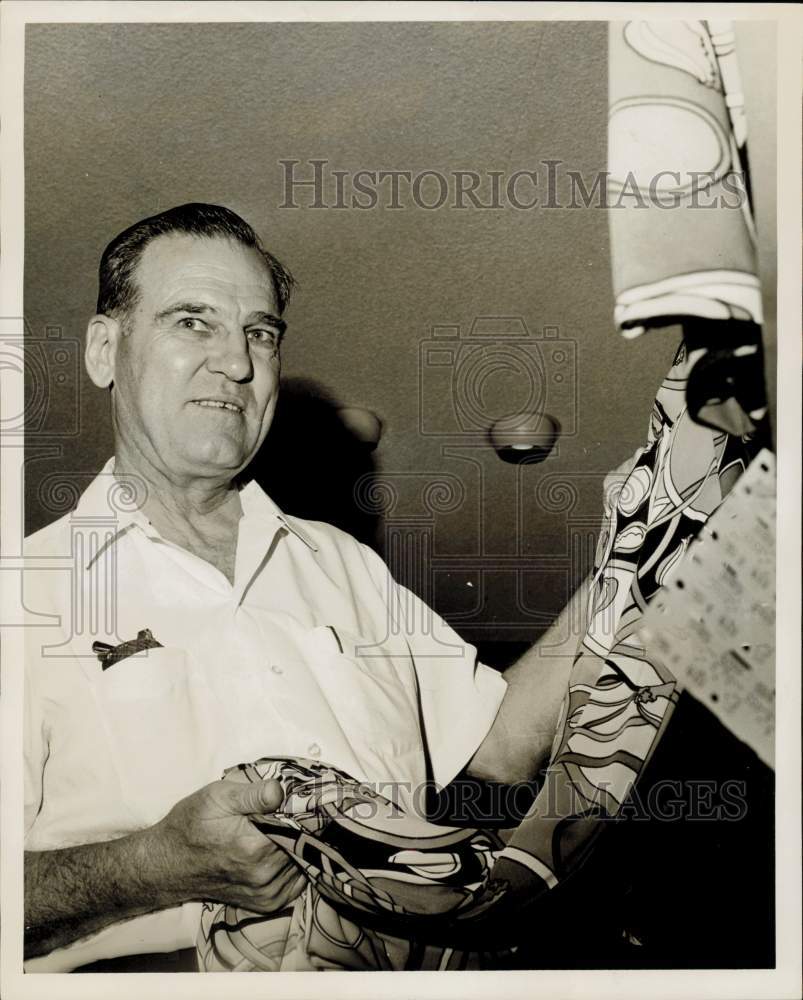 1967 Press Photo Bryan Maxes, Houston home builder, picks gift from gown rack.- Historic Images