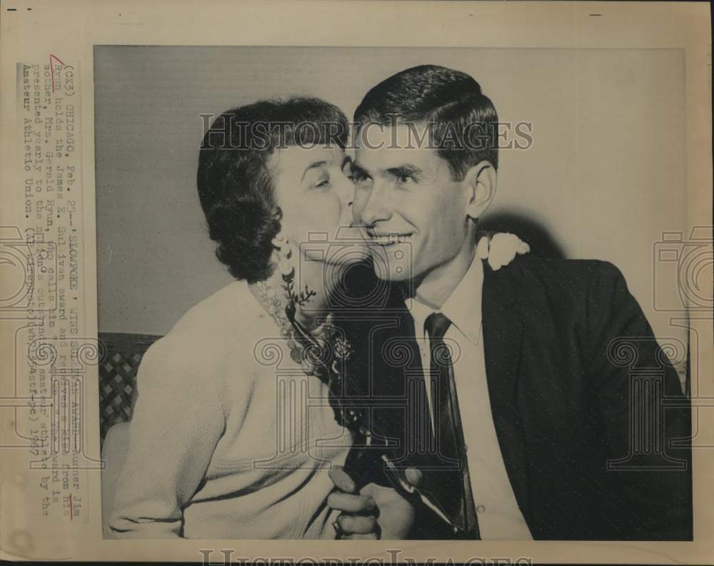 1967 Press Photo Jim Ryun holds Sullivan award and kissed by mother in Chicago.- Historic Images