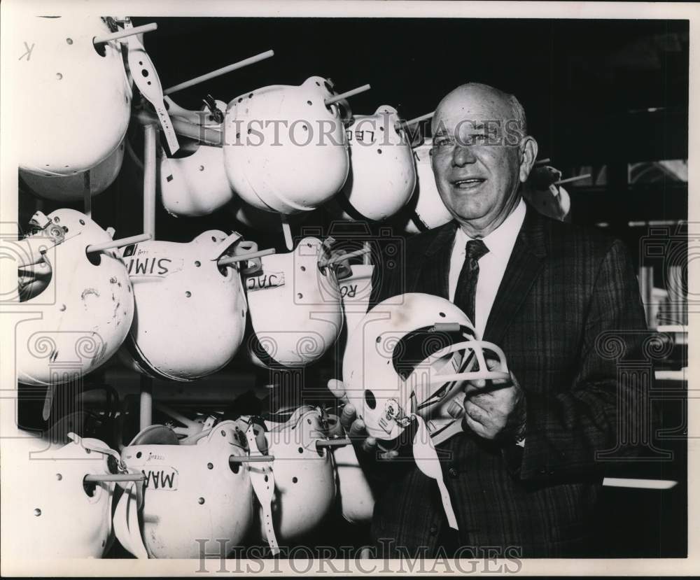 1963 Press Photo Homer Norton views football helmets. - hps13913 - Historic Images