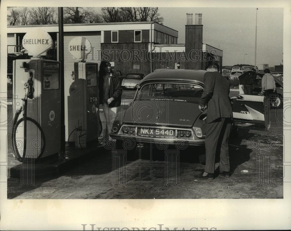 1966 Press Photo Mr Moss stops for gas on drive to Nottingham England - Historic Images