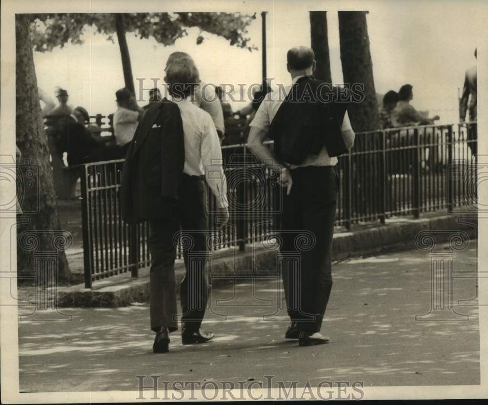 1975 Press Photo Two guys walk with coats off at Battery Park - Historic Images