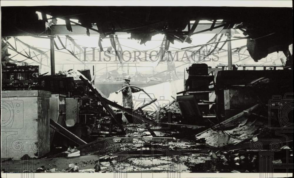 1965 Press Photo Fireman inspects rubble after Farka Red Bud Stall fire- Historic Images