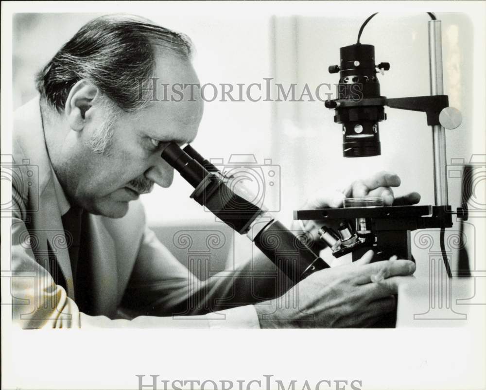 1983 Press Photo Doctor Richard Seed examines a sample in his laboratory- Historic Images