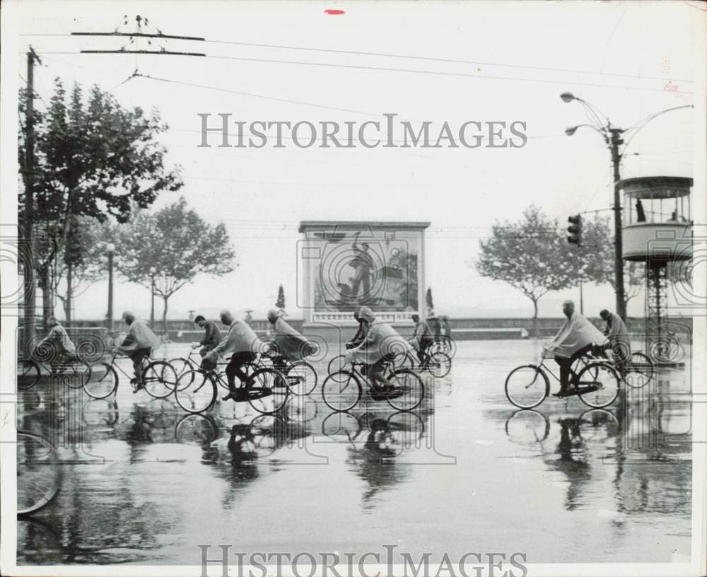 1987 Press Photo People ride bikes on way to work in the rain in Shanghai, China- Historic Images