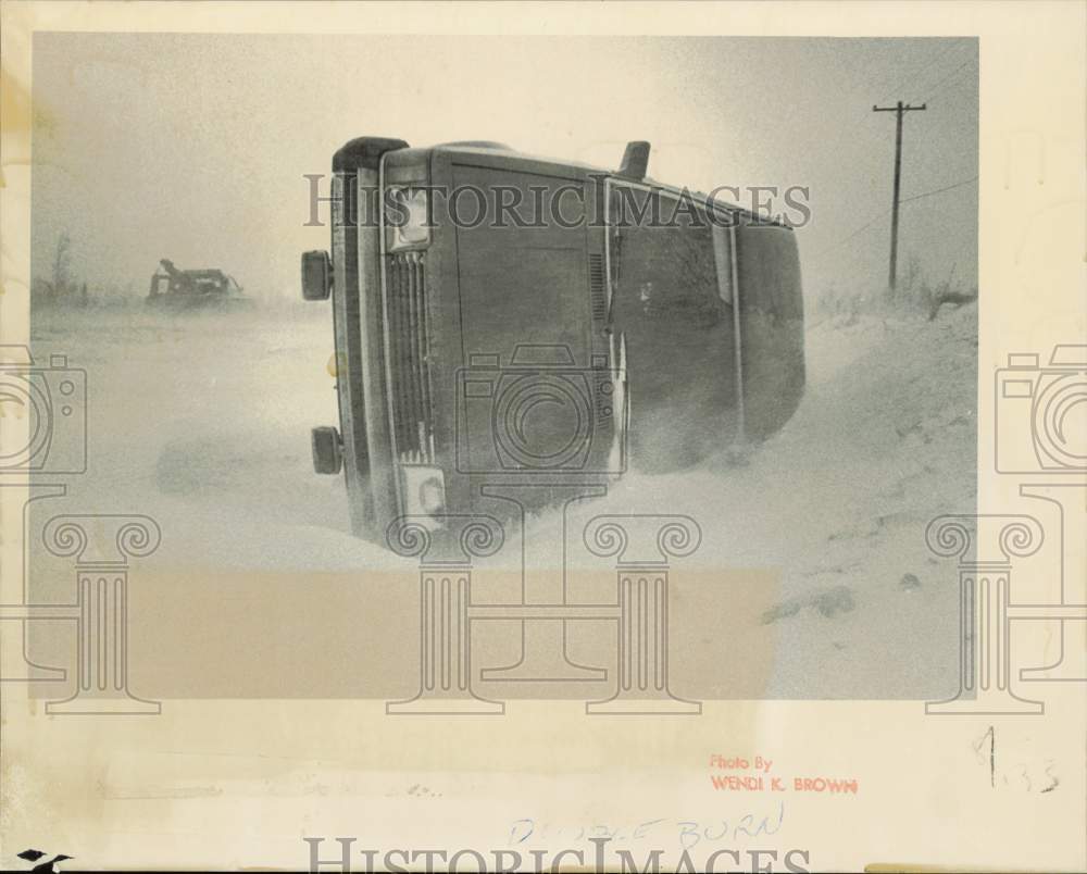 1985 Press Photo Car Turned on Side in Snow during Wild Weather in Anchorage, AK- Historic Images