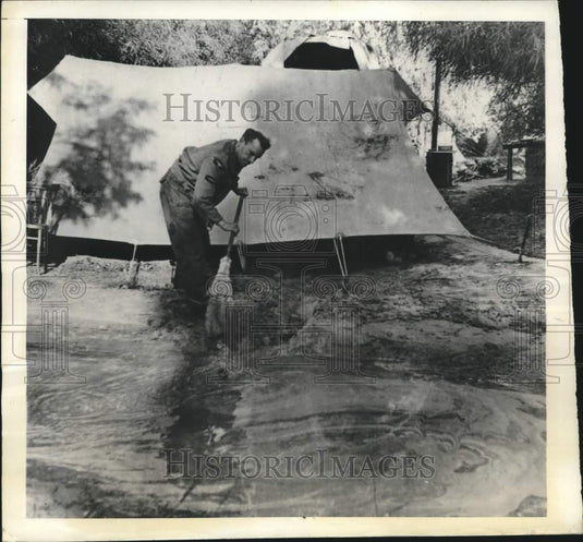 1943 British airman sweeps water away from tent in Tripolitania - Historic Images