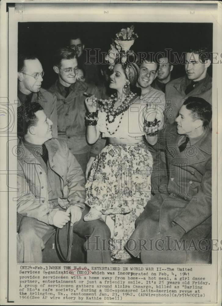 1942 Soldiers gather around Alzira Camargo at USO event - Historic Images