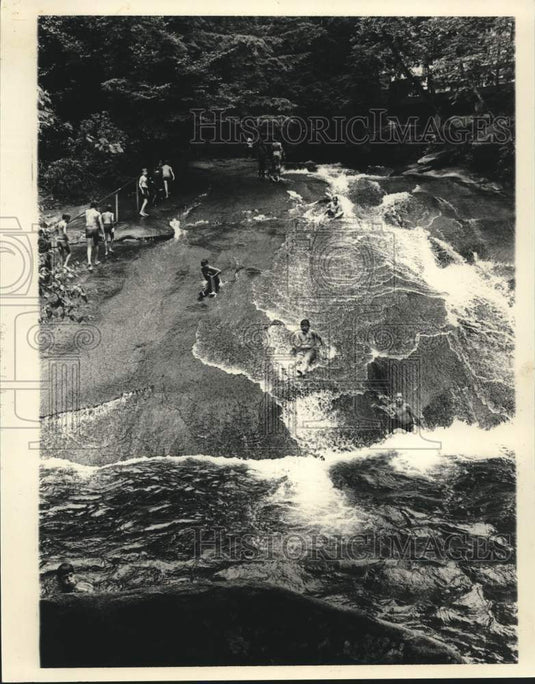 1983 Youngsters enjoy trip on nature's water slide at Sliding Rock - Historic Images