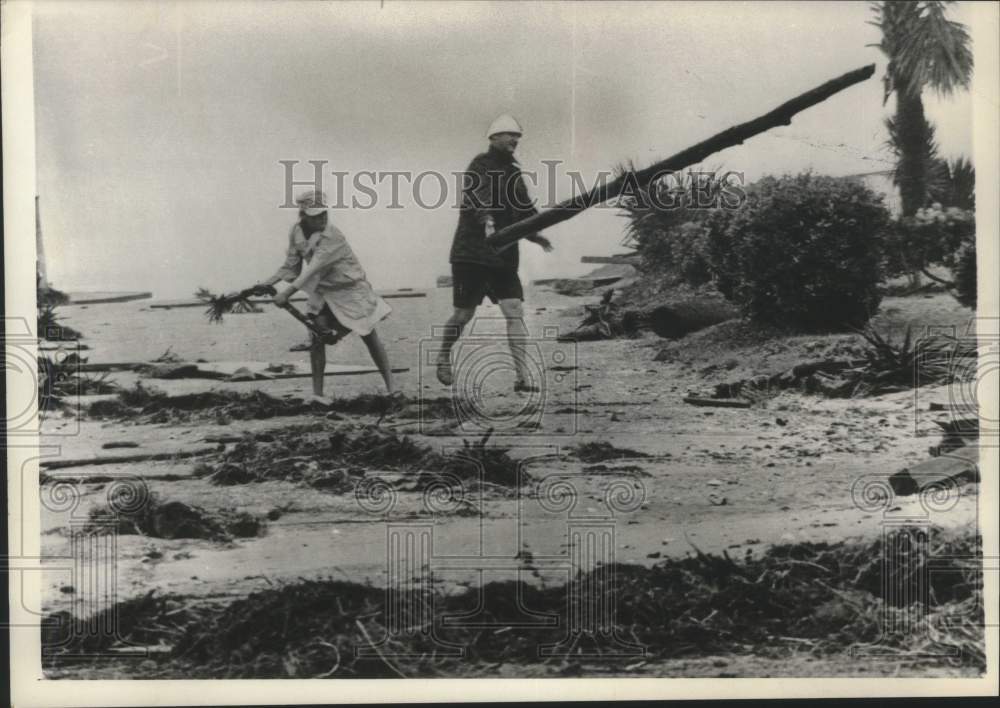 1964 A father and son clear debris caused by Hurricane Dora-Historic Images