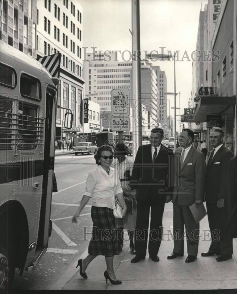 1959 Business men watch the patrons leave the bus to shop downtown - Historic Images