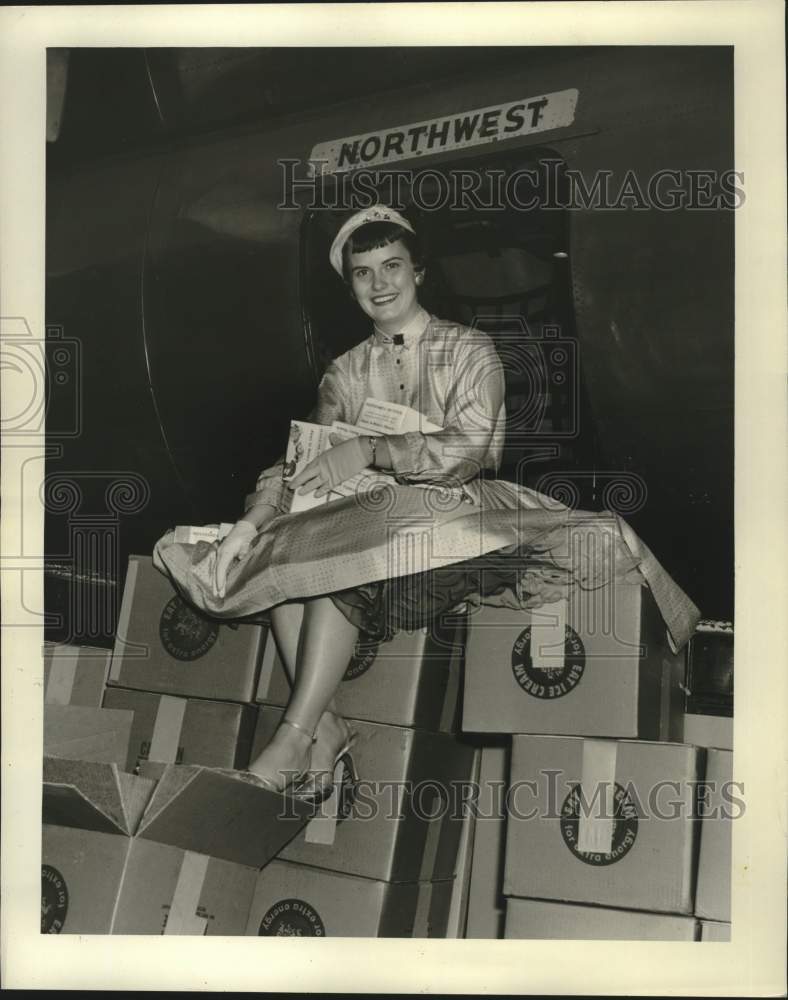 1955 Ms. Maley sits on the boxes of butter near the Northwest plane-Historic Images