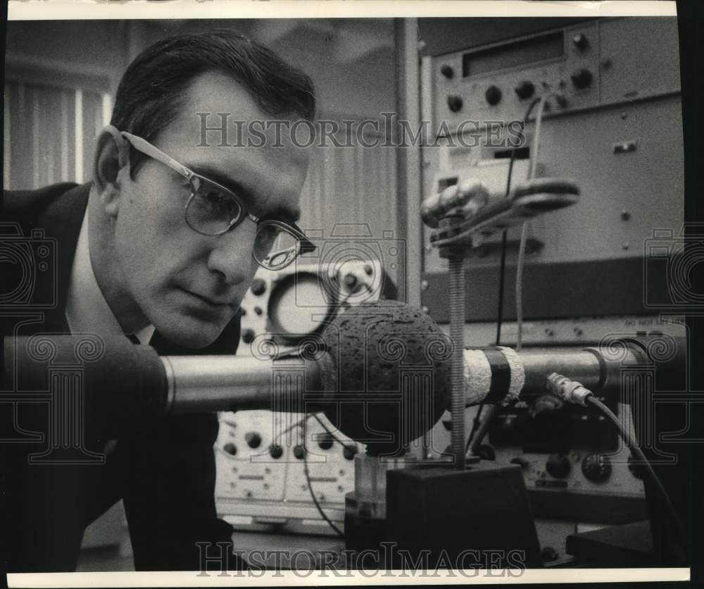 1967 Press Photo Tom Bur with a sphere of rock in lunar study of rock Properties - Historic Images