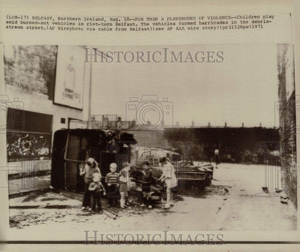 1971 Press Photo Children play among burned cars in riot-torn Belfast, Ireland- Historic Images