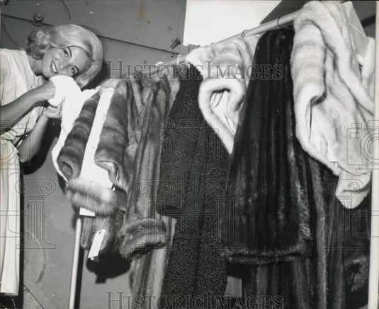 1964 Press Photo Woman with a rack of fur coats at 1st National Bank.- Historic Images
