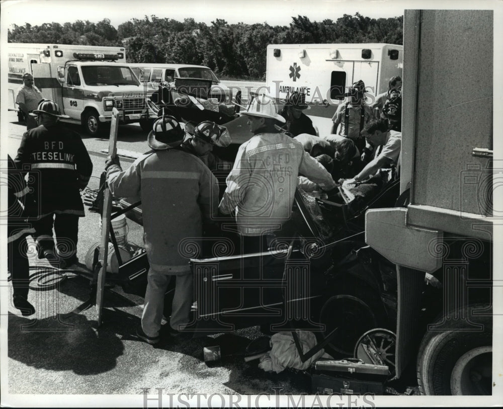 1990 Press Photo Firefighters &amp; rescuers remove a man from his car on I-94-Historic Images