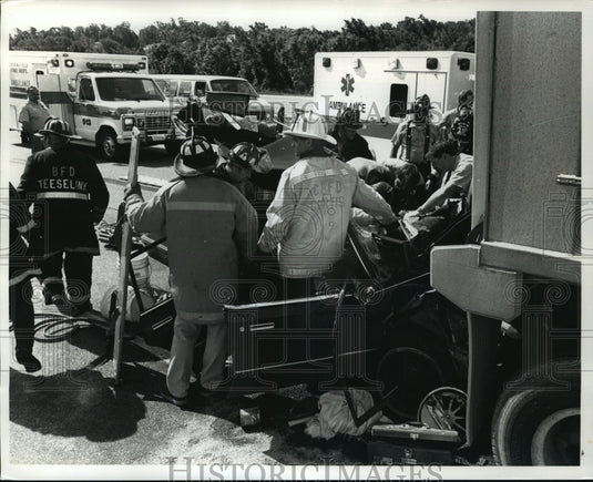 1990 Press Photo Firefighters & rescuers remove a man from his car on I-94-Historic Images