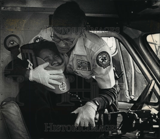 1992 Press Photo Rescuer helps injured school bus driver near Milwaukee Stadium - Historic Images