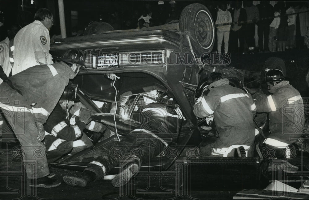 1990 Press Photo Firefighters work to remove body of a man killed in car crash - Historic Images