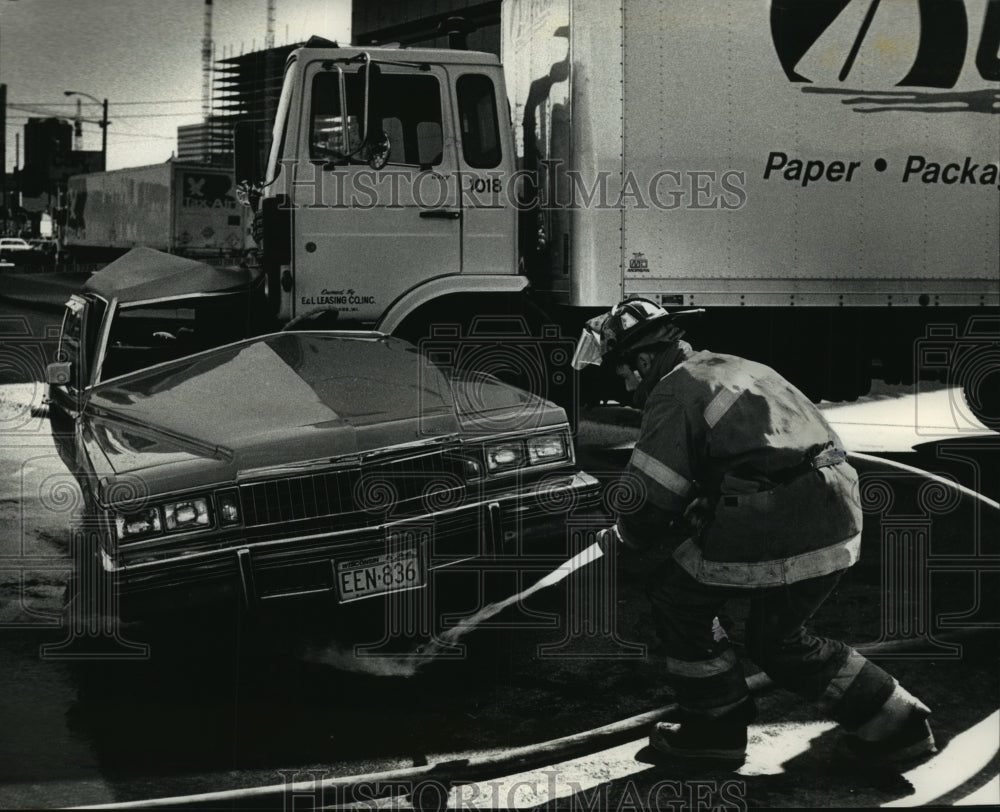 1990 Press Photo Firefighter at Car-truck accident at N 4th &amp; W Juneau Ave - Historic Images