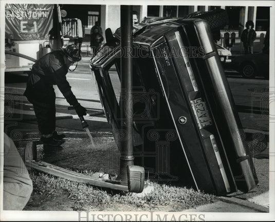 1990 Press Photo Car collision on E State & N Jackson Sts overturned the car - Historic Images