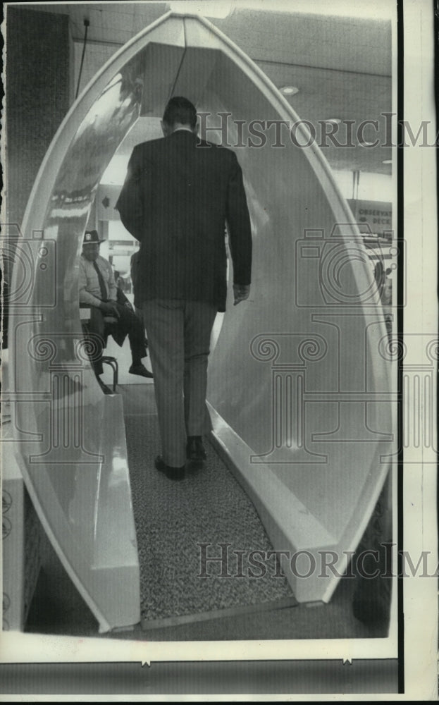 Press PhotoAn airline passenger walked through a newly installed metal detector- Historic Images