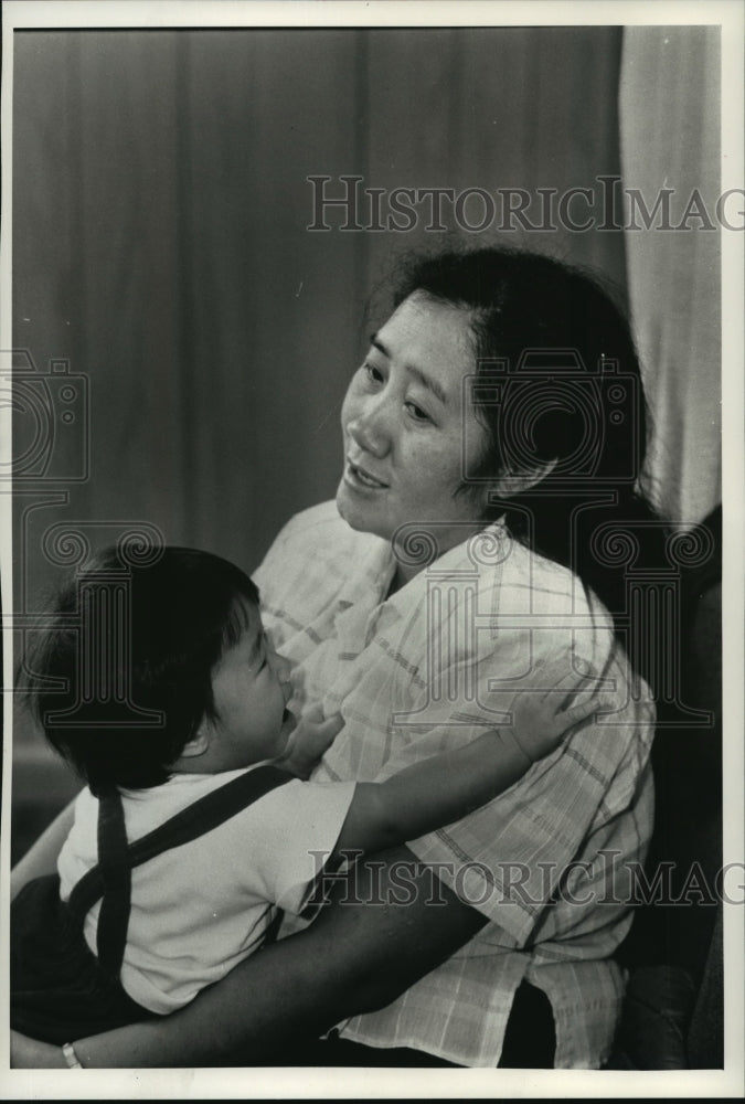 1980 Press Photo May Thao Her holding her daughter Sunshine, waiting for news - Historic Images