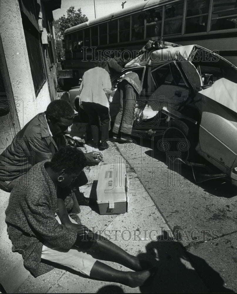 1990 Press Photo Woman injured in a car-school bus crash waits for medical help - Historic Images