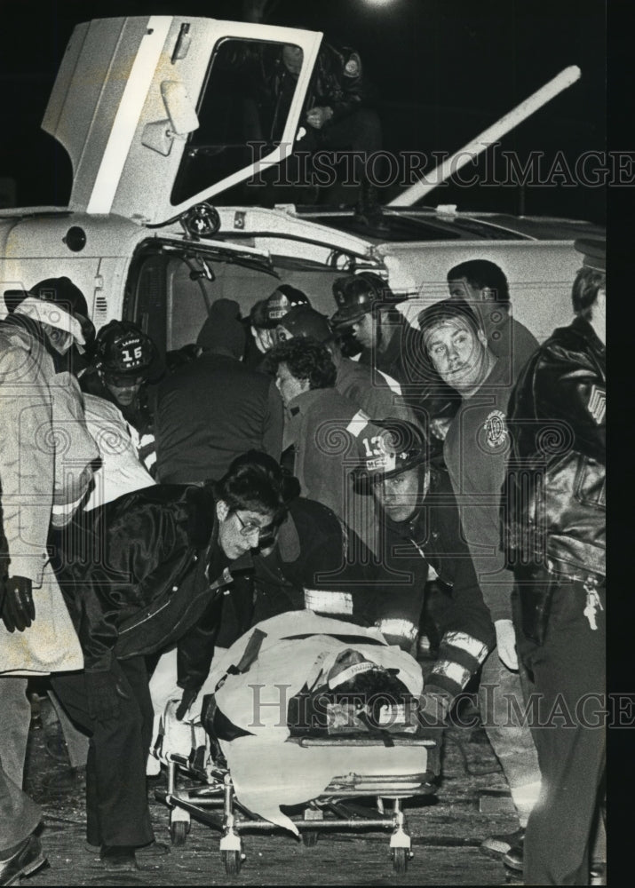 1990 Press Photo Rescue personnel move a police officer who was injured - Historic Images