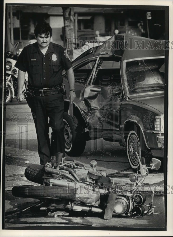 1990 Press Photo Police Officer Richard Villanueva inspects the wreckage - Historic Images