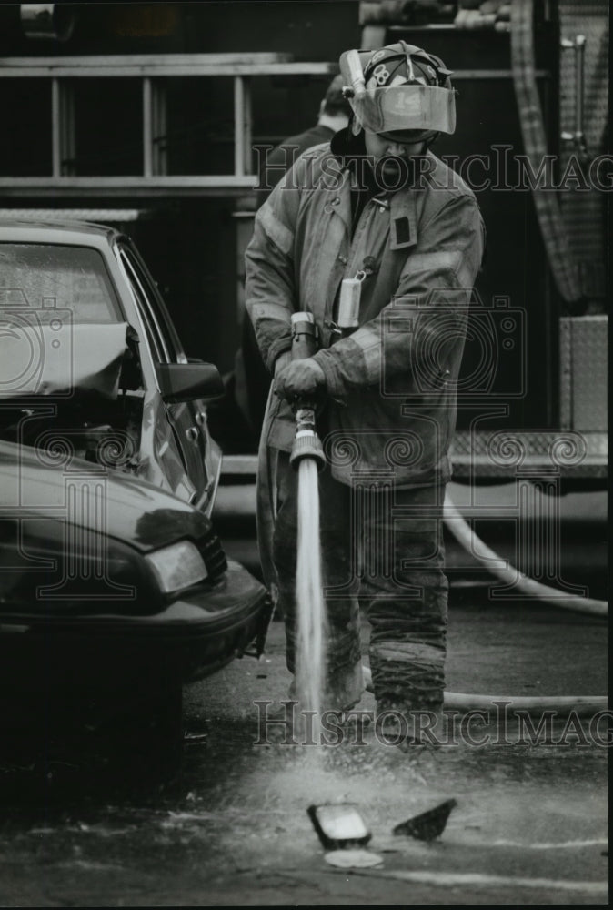 1993 Press Photo A firefighter hoses down the scene of a traffic accident - Historic Images