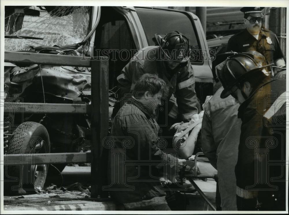 1993 Press Photo Police and fire rescue personnel work to extract a woman - Historic Images