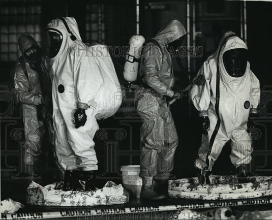 1989 Press Photo Firefighters wearing protective gear wash down other firemen - Historic Images