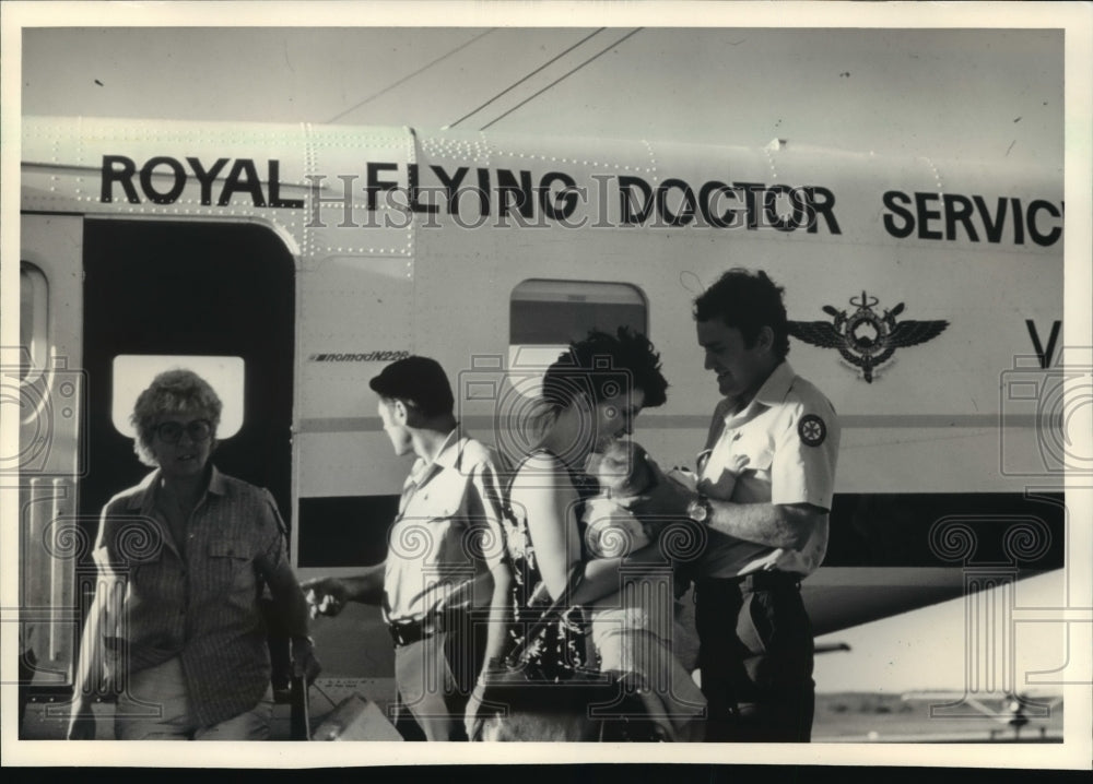 1987 Press Photo Members of Royal Flying Doctor Service land with young patient - Historic Images