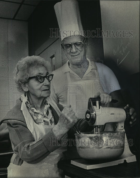1985 Press Photo Willard Pollak teaching 100 yr old Erna Abraham bake cookies - Historic Images