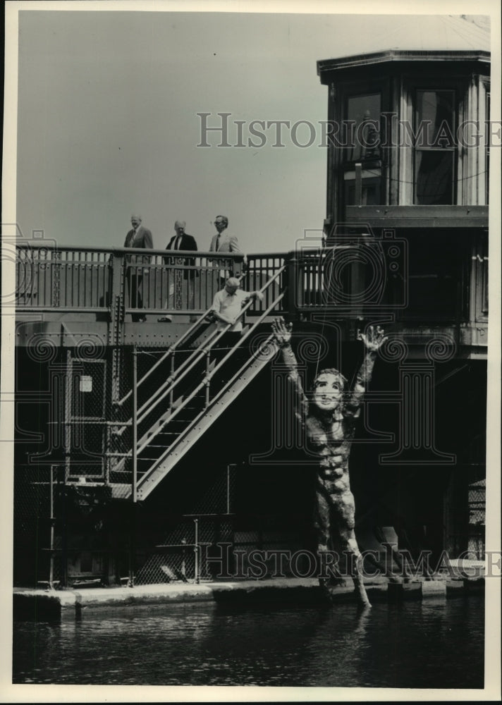 1987 Press Photo Fiberglass superhero statue under State St bridge by T Agnew - Historic Images