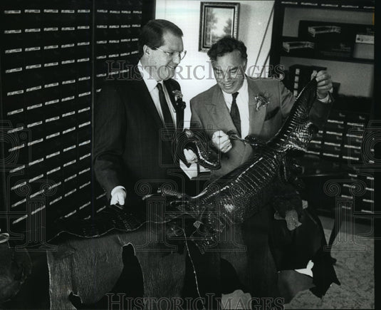 1990 Press Photo Patrick Philmon and Mr. Stollenwerk look over an alligator skin - Historic Images