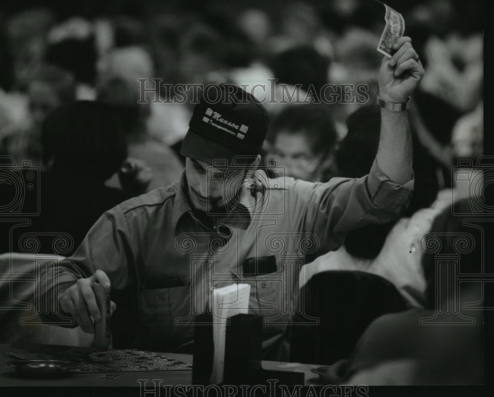 1993 Press Photo Man Marks Bingo Card Raising Dollar in Air - mja06340 - Historic Images
