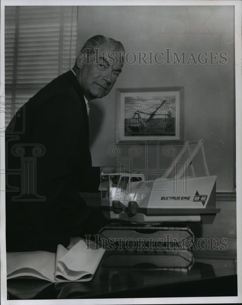 1962 Press Photo Eugene Berg examines a model of one of his company&#39;s products - Historic Images